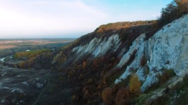 Sinema 4 k hava manzara. Yeşil çimenli kayalık tebeşir tepeler, dağlar ve bir nehir üzerinde uçan