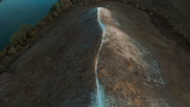 Filmische 4 k luchtfoto. Vliegen over groene grazige rotsachtige krijt heuvels, bergen en een rivier — Stockvideo