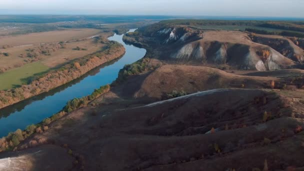 Vista aérea cinematográfica 4k. Voando sobre colinas verdes de giz rochoso gramado, montanhas e um rio — Vídeo de Stock
