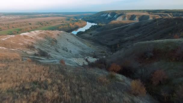 Vista aerea 4k cinematografica. Volare su verdi colline di gesso roccioso erboso, montagne e un fiume — Video Stock