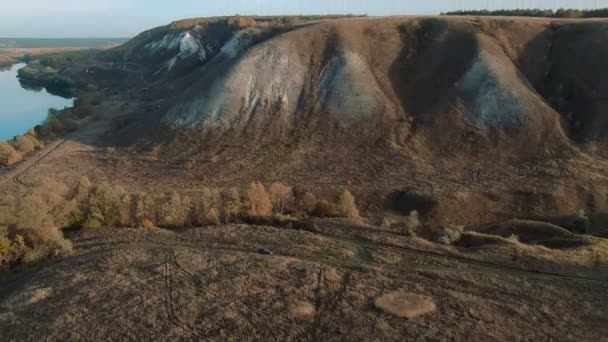 Vue aérienne cinématique 4k. Survoler les collines verdoyantes de craie rocheuse, les montagnes et une rivière 