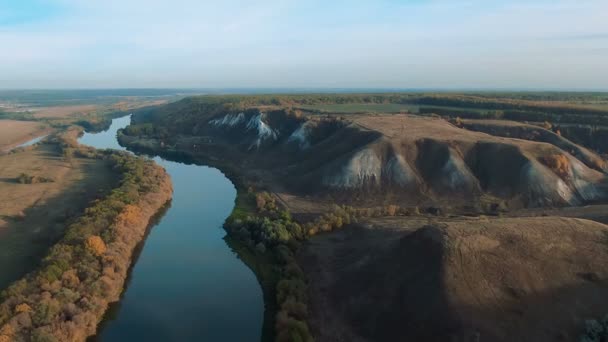 Vista aérea cinematográfica de 4k. Volando sobre verdes colinas de tiza rocosa, montañas y un río — Vídeos de Stock