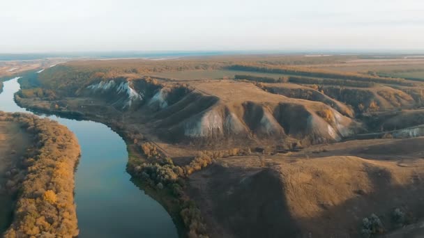 Vista aérea cinematográfica de 4k. Volando sobre verdes colinas de tiza rocosa, montañas y un río — Vídeos de Stock