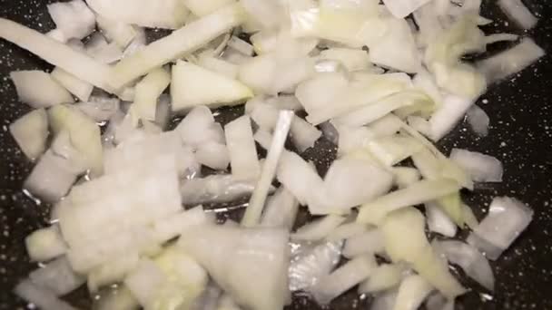 Fritamento de cebola de close-up em uma panela em óleo em câmera lenta — Vídeo de Stock