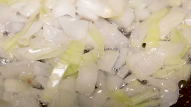 Крупним планом цибулю смажать на сковороді в олії при повільному русі — стокове відео
