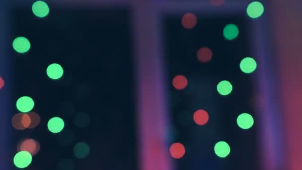 Boże Narodzenie Girlanda z kolorowymi światłami przez okno przed na tle miasta i ruch samochodów, szczelnie-do góry. Niewyraźne lights Christmas. Bokeh. — Wideo stockowe