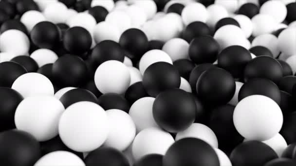 Animazione 3D in bianco nero 4k da un mucchio di sfere astratte e palline rotolanti e cadenti dall'alto verso il basso . — Video Stock