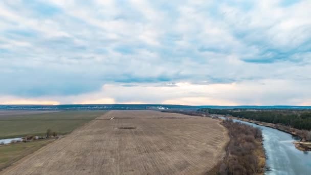 Drone sukut güzel kırsal manzara, bulutlar, hızlı hareket eden sarı mavi gökyüzü hareket yukarıya zaman atlamalı ile yeşil alanlar ve renkli günbatımı ufuk ekili — Stok video