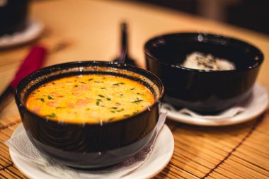 Tom yam kong veya Tom yum, Tom yam olduğunu bir baharatlı açık çorba tipik Tayland ve No.1 Tayland yemek mutfağı. Tom yam kong ahşap masa üzerinde. Tayland gıda.