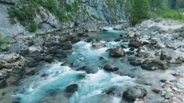 Hava 4k Bir dağ nehrinin üst görünümü. Alp ler, ormanlar arasında kayaların arasında bir geçitte akar. Yaz aylarında, nehir buzulların erimesi nedeniyle kalınlaşır..