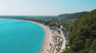 Havadan 4k görünümü mavi-yeşil deniz ile tropikal plaj, yağmur ormanlarının yeşil dağlar. Cennette gözlerden uzak gizli plaj. Mavi gökyüzü, turkuaz sakin okyanus dalgaları su.