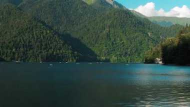 Turkuaz su ve yeşil ağaç ile dağ gölü. Dağlar, orman ve göl ile güzel yaz manzara. Havadan 4k Görünüm. Drone shot dolly zoom etkisi.