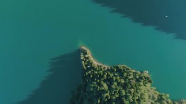 Turkuaz su ve yeşil ağaç ile dağ gölü. Dağlar, orman ve göl ile güzel yaz manzara. Havadan 4k Görünüm. Drone güzel bir dağ ormanı gölü üzerinde vuruldu