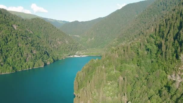 Hegyi tó türkizkék vízzel és zöld fa. Gyönyörű nyári táj hegyekkel, erdővel és tóval. Aerial 4k nézet. Drone lövés egy gyönyörű hegyi erdei tó — Stock videók