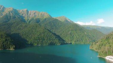 Turkuaz su ve yeşil ağaç ile dağ gölü. Dağlar, orman ve göl ile güzel yaz manzara. Havadan 4k Görünüm. Drone güzel bir dağ ormanı gölü üzerinde vuruldu