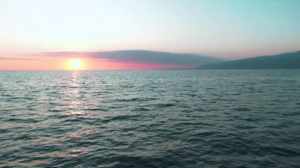 Вид снизу. Потрясающее солнце заката над морем. Красивые кинематографические сцены. Золотое солнце заходит за горизонт, летит над поверхностью воды в замедленной съемке — стоковое видео