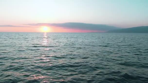 Vue aérienne 4k. Superbe soleil couchant sur la mer. Belle scène cinématographique. Soleil doré se couche sur l'horizon, volant au-dessus de la surface de l'eau au ralenti — Video