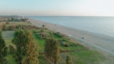 Güzel bir tropikal plaj ve deniz dalgaları hava 4k üst görünümü. Gün batımında kumlu plaj üzerinde uçan.