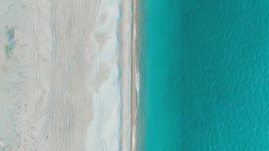 Güzel bir tropikal plaj ve deniz dalgaları hava 4k üst görünümü. Gün batımında kumlu plaj üzerinde uçan.
