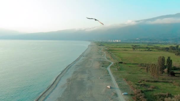 Εναέρια 4K κορυφαία θέα από μια όμορφη τροπική παραλία και θαλάσσια κύματα. Πετώντας πάνω από την αμμώδη παραλία στο ηλιοβασίλεμα. — Αρχείο Βίντεο