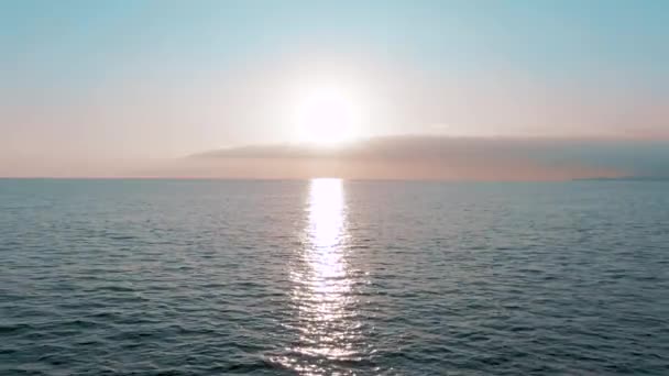 空中4Kビュー。海の上に見事な夕日の太陽。美しい映画シーン。黄金の太陽が地平線の上に沈み、水面の上を飛ぶ — ストック動画