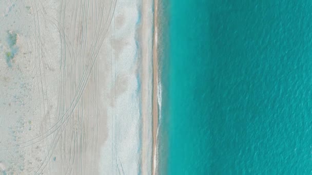 Aerial 4K topputsikt över en vacker tropisk strand och havsvågor. Flyga över sandstranden vid solnedgången. — Stockvideo