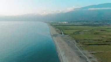 Güzel bir tropikal plaj ve deniz dalgaları hava 4k üst görünümü. Gün batımında kumlu plaj üzerinde uçan.