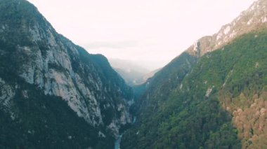 Havadan 4k görünüm. Gün batımında güzel sıradağların üzerinde uçuyor. Güçlü uçurumlar ve geçitler