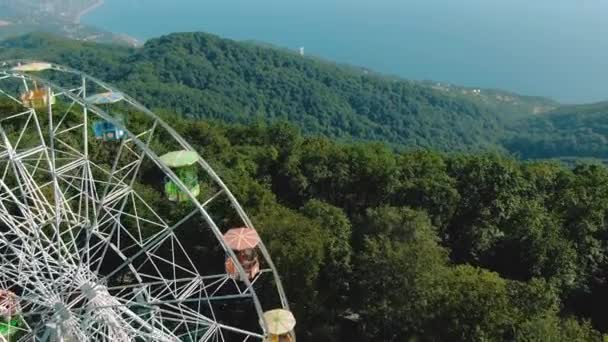 Aerial 4K-vy. Ett pariserhjul snurrar ovanpå ett berg. Fantastisk utsikt över bergen och havet. Attraktion för vuxna och barn — Stockvideo