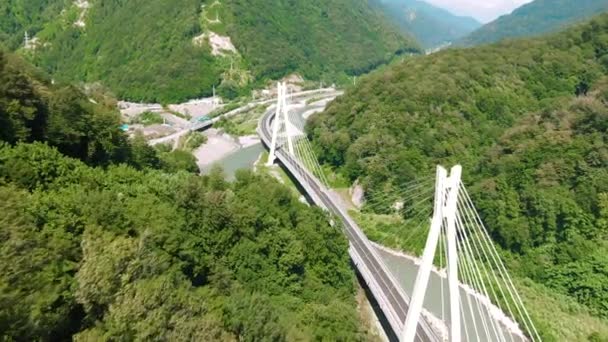 Aerial 4k view. Suspension bridge over the river. Flying over the bridge among mountains and rocks. — Stock Video