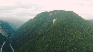 Havadan 4k görünüm. Gün batımında güzel sıradağların üzerinde uçuyor. Güçlü uçurumlar ve geçitler