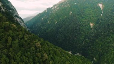 Havadan 4k görünüm. Gün batımında güzel sıradağların üzerinde uçuyor. Güçlü uçurumlar ve geçitler