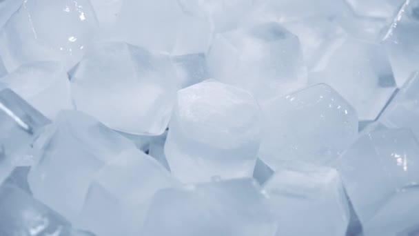 Macro de cubos de hielo de agua clara que se derriten en cámara lenta sobre un fondo blanco. Concepto: agua pura de manantial de montaña, hielo, cócteles, alimentos frescos y congelados . — Vídeo de stock