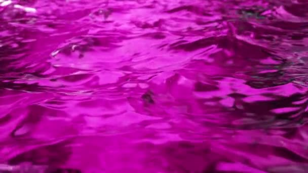 De l'eau pure violette dans la piscine avec des reflets lumineux. Au ralenti. Boucle sans couture rendu 3d. — Video