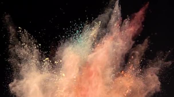 Super Zeitlupe Explosion von bunten Puder auf dunklem, isoliertem Hintergrund. Puderklumpen fliegen nach oben und vermischen sich mit dem Rauch. — Stockvideo