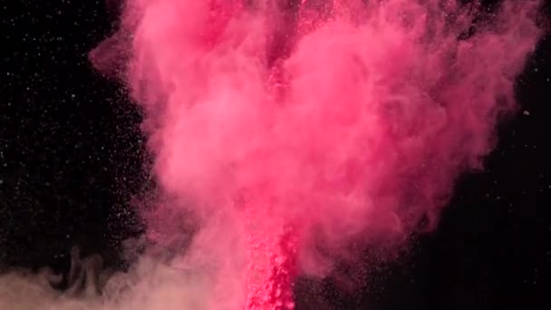 Super powolny wybuch kolorowego czerwonego proszku na ciemnym, odizolowanym tle. Kawałki proszku wzlatują w górę i mieszają się z dymem. — Wideo stockowe