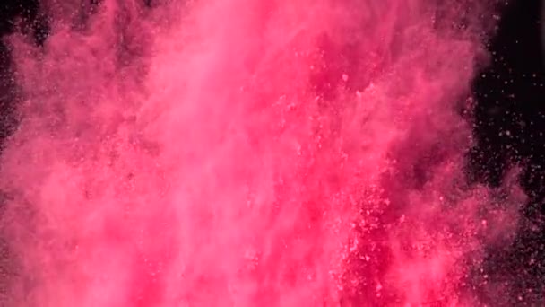 Super slow motion explosion av färgglada rött pulver på mörk isolerad bakgrund. Pulverklumpar flyger uppåt och blandas med röken. — Stockvideo