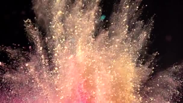 Esplosione super slow motion di polvere multicolore colorata su sfondo scuro isolato. I grumi di polvere volano verso l'alto e si mescolano con il fumo. — Video Stock