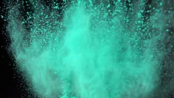 Super slow motion explosion av färgglada blått pulver på mörk isolerad bakgrund. Pulverklumpar flyger uppåt och blandas med röken. — Stockvideo