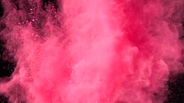 Super slow motion explosion av färgglada rött pulver på mörk isolerad bakgrund. Pulverklumpar flyger uppåt och blandas med röken. — Stockvideo