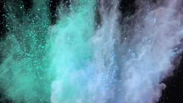 Super slow motion explosion of colorful multicolored powder on dark isolated background. Lumps of powder fly upwards and mix with the smoke. — Stock Video