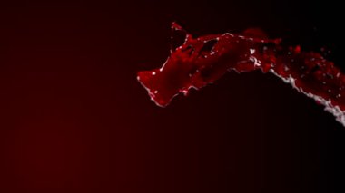 Kırmızı arka planda yavaş çekimde muhteşem bir şarap sıçraması.