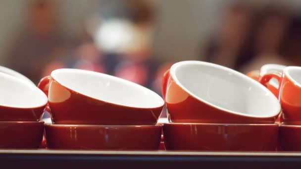 Prázdné červené šálky pro espresso a na kávu a mléko stojí a zahřívání na povrchu kávovar