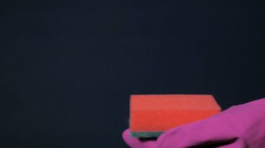 Kırmızı lastik eldiven erkek elinde sünger. Beyaz köpük sprey olabilir dışarı su sıçramalarına.