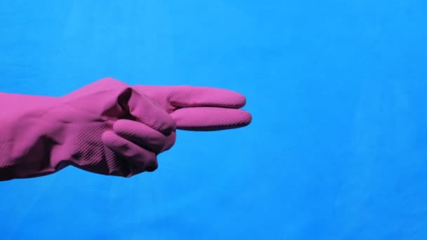 Sprzątaczka ręka w fioletowy gumowej rękawicy na niebieskim tle. Podnośniki nożycowe ręce. — Wideo stockowe