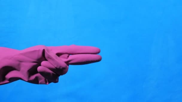 Καθαριστικό χεριών σε μωβ καουτσούκ γάντι σε μπλε φόντο. Τα χέρια του ψαλιδιού. — Αρχείο Βίντεο