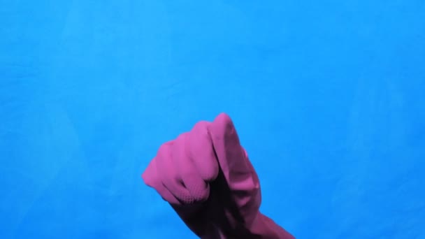 Чистая рука в фиолетовой резиновой перчатке подсчет от 0 до 5 на синем фоне . — стоковое видео