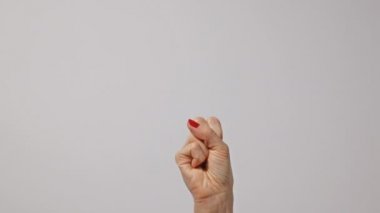 İki parmağını kaldıran ve barış ya da zafer sembolü gösteren bir kadın ya da bir elinde işaret diliyle arka planda iki parmağını kaldıran bir kadın. Taze kırmızı manikürlü tırnaklar..