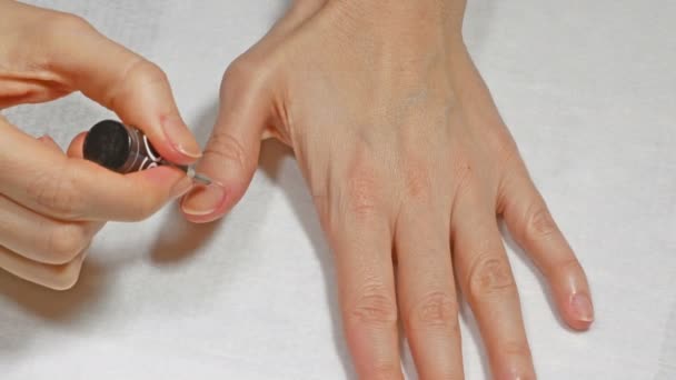 Aanbrengen van de basis op de nagels van de linkerhand — Stockvideo