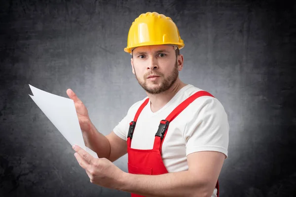 Obrero de la construcción enojado sosteniendo papeles — Foto de Stock